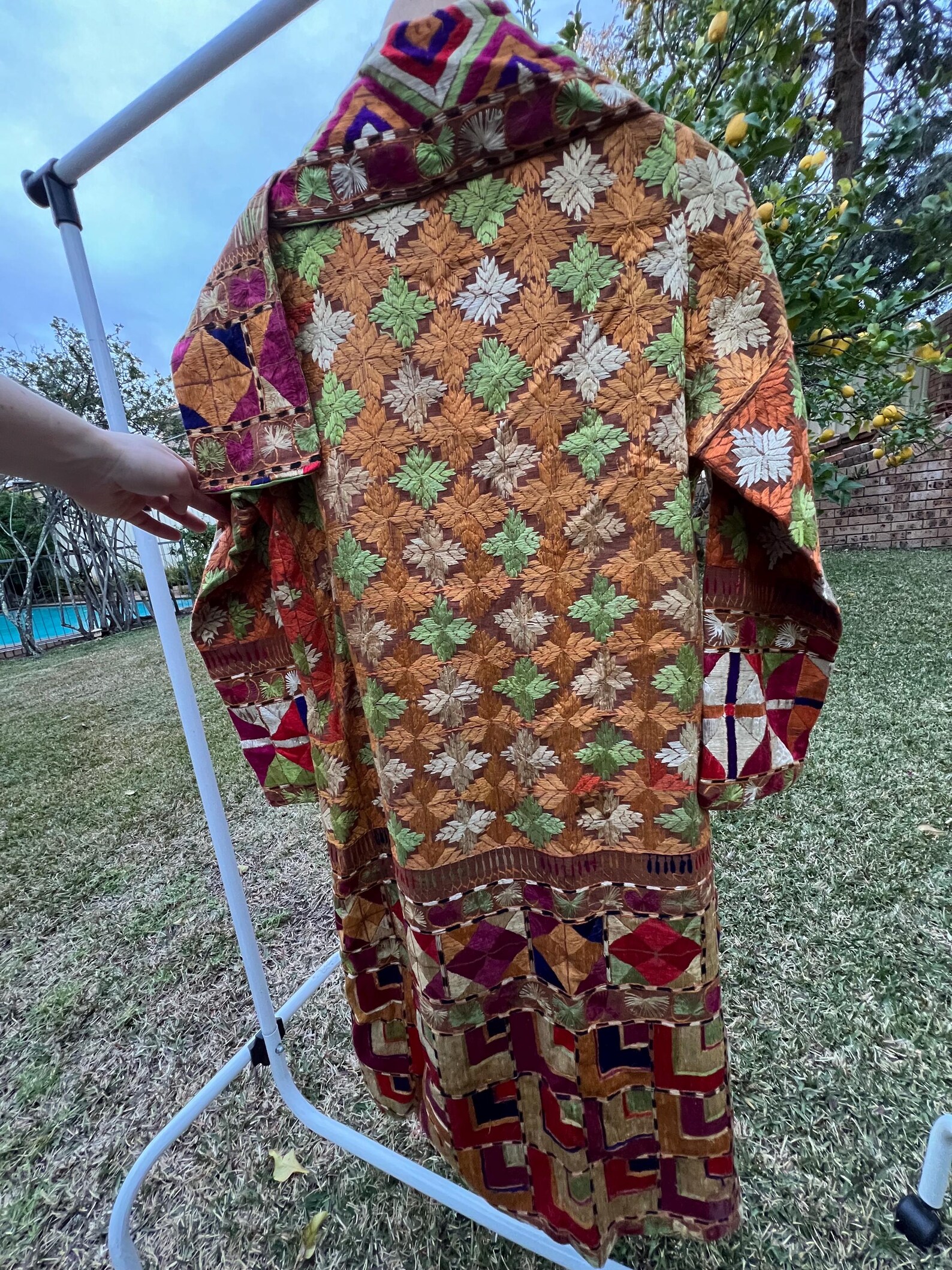 Embroidered coat back view — chinar leaf pattern with geometric borders
